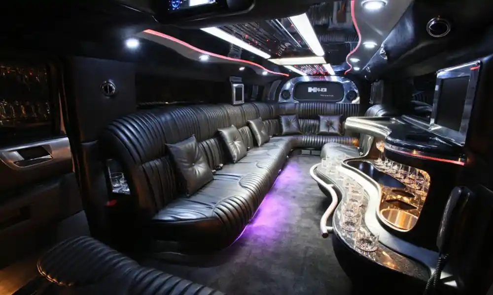 Interior of black stretch limo with leather seating, ambient lighting, and bar setup in Summit, NJ.
